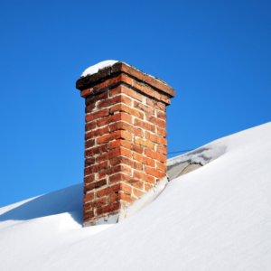 a masonry chimney surrounded by a snowy roof